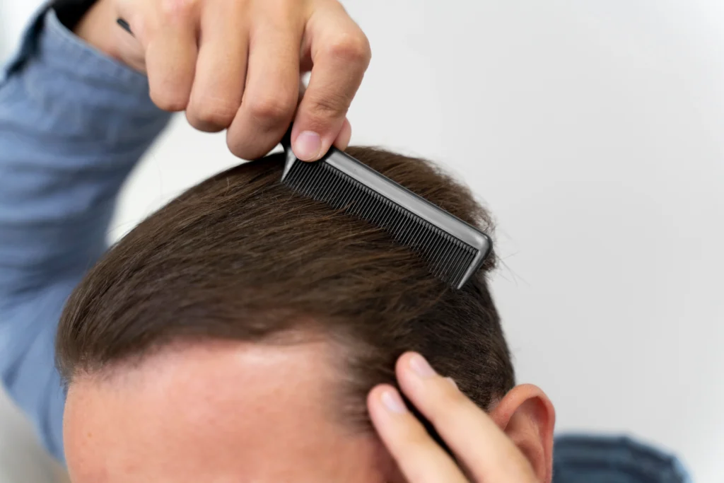 The image shows a man combing his hair, focusing on the top of his head